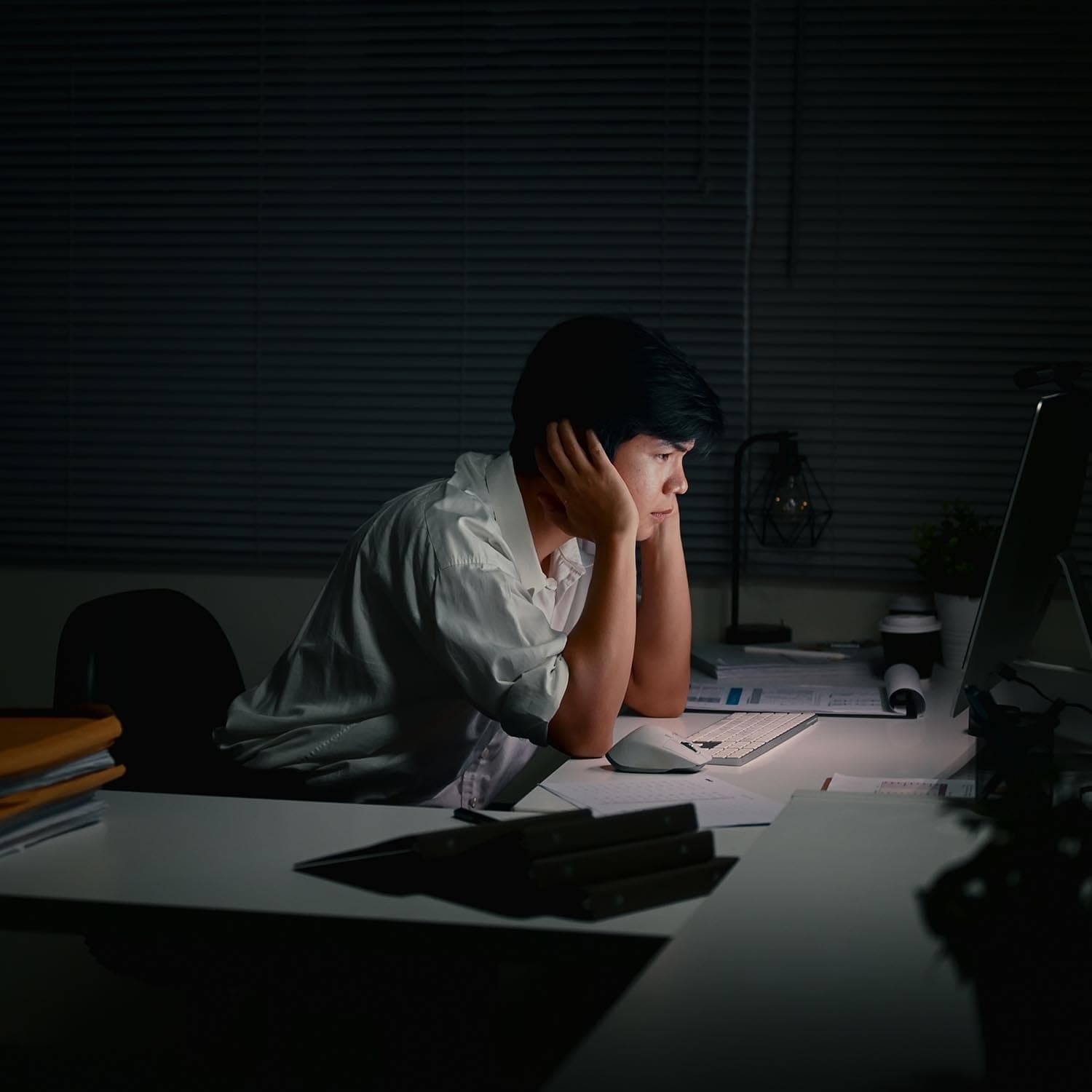 Person working alone at night on a laptop in a dimly lit room