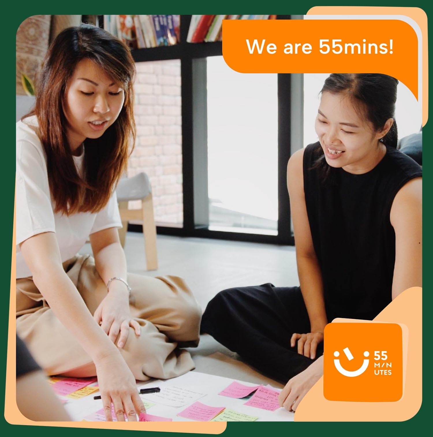 Team members sitting on the floor and collaborating in an office with post-its and markers